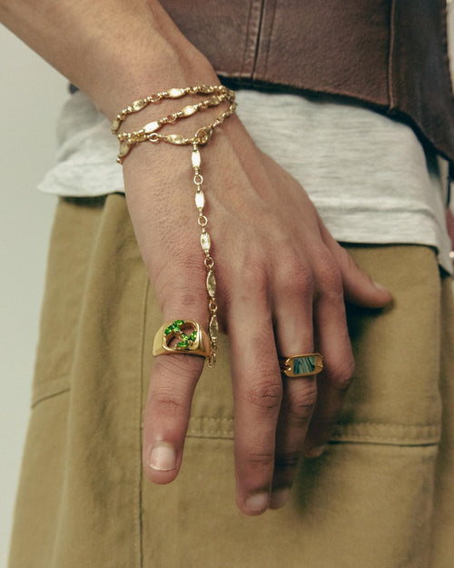 Closeup of hand next to khaki pants wearing MAPLE rings & jewelry
