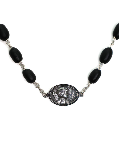 Necklace with black beads and a silver medallion on a white background