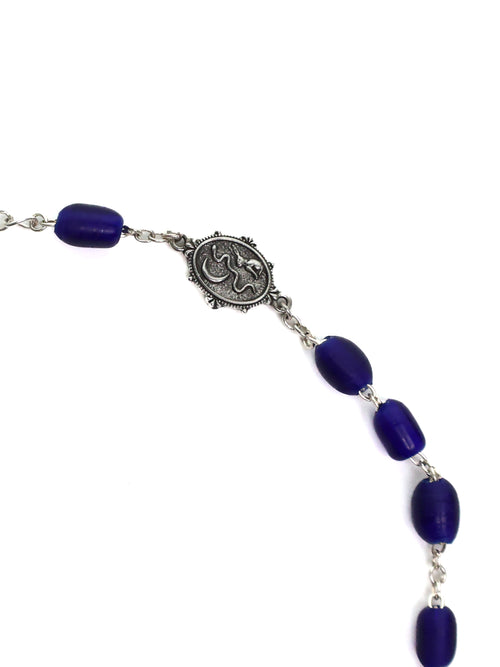 Bracelet with blue beads and silver medallion on a white background