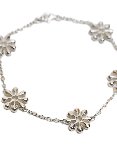 Silver bracelet with sun inspired designs on a white background