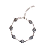 Silver bracelet with decorative medallions on a white background