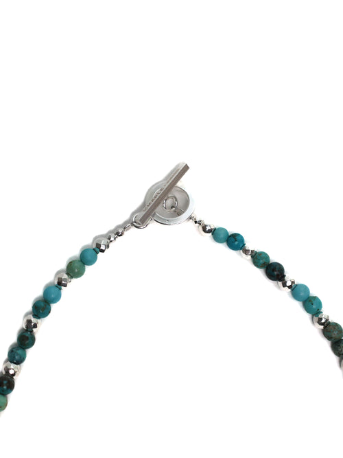 Bracelet with green beads and silver clasp on a white background