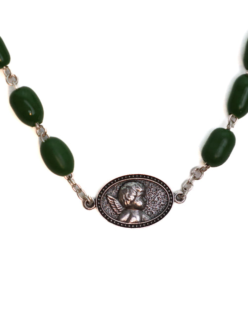 Necklace with green beads and a central medallion on a white background