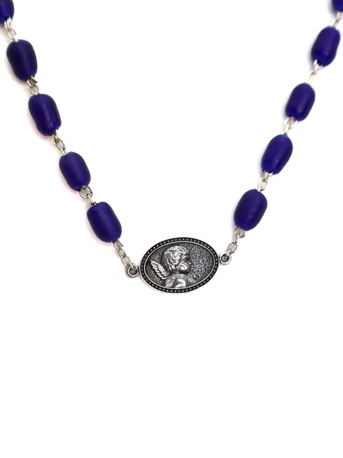 Necklace with blue beads and a silver medallion on a white background