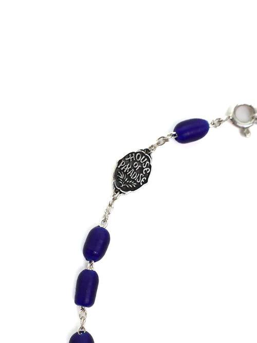 Bracelet with blue beads and silver medallion on a white background