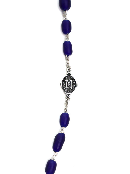 Necklace with blue beads and a silver medallion on a white background