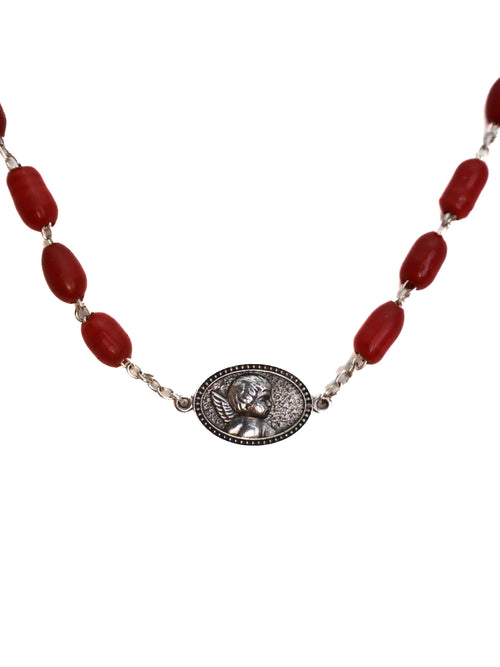 Necklace with red beads and a silver medallion on a white background
