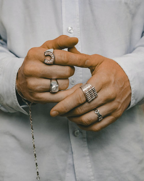 Man's hands clasped hands wearing MAPLE rings