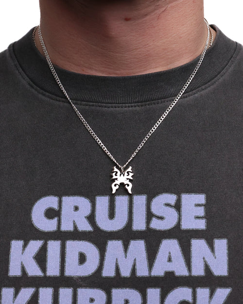 Person wearing a necklace with a horse pendant on a black t-shirt with text.