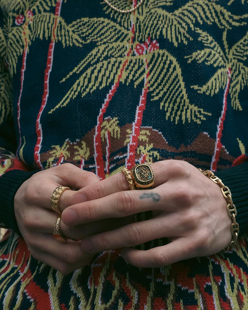 Hands in front of knitted palm tree sweater showcasing off MAPLE Weekend Champion Ring 14K Gold