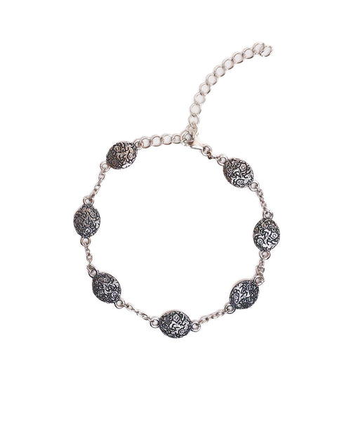 Silver bracelet with decorative medallions on a white background