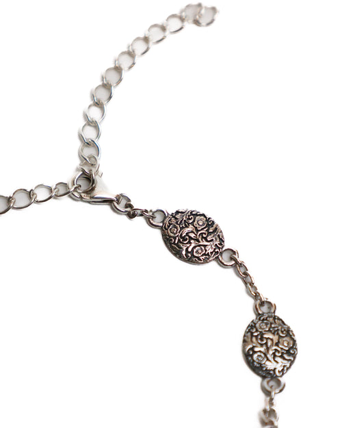 Silver bracelet with decorative medallions on a white background