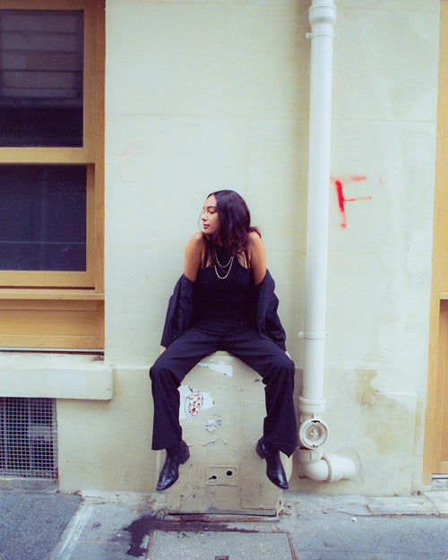 Anissa sitting on white electrical box against a wall