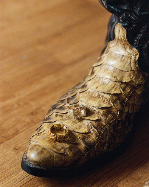 MAPLE Chalice ring and Scorpio ring on top of a snakeskin cowboy boot