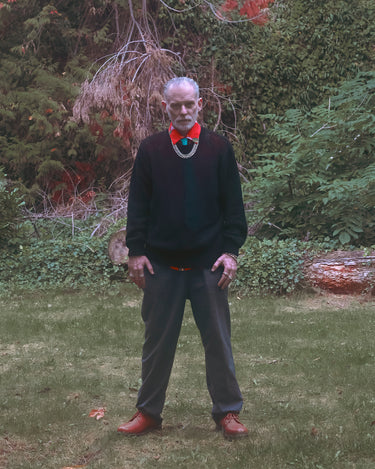 FW24 Editorial man standing in front of trees and bushes wearing MALPE jewelry