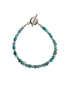 Bracelet with turquoise beads and silver clasp on a white background