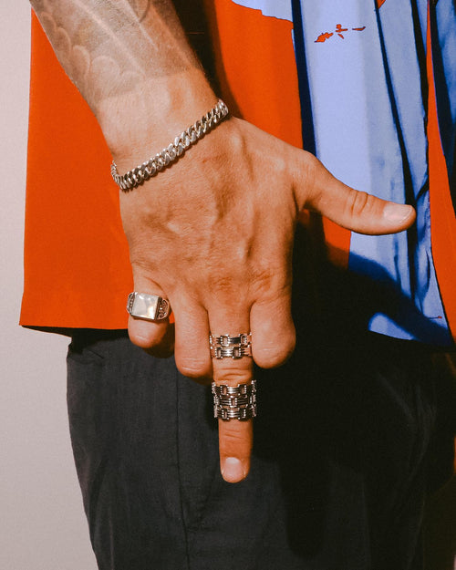 Man's hand resting on it's side wearing MAPLE bracelets & rings